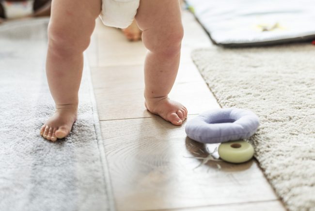 Closeup of baby’s legs while standing