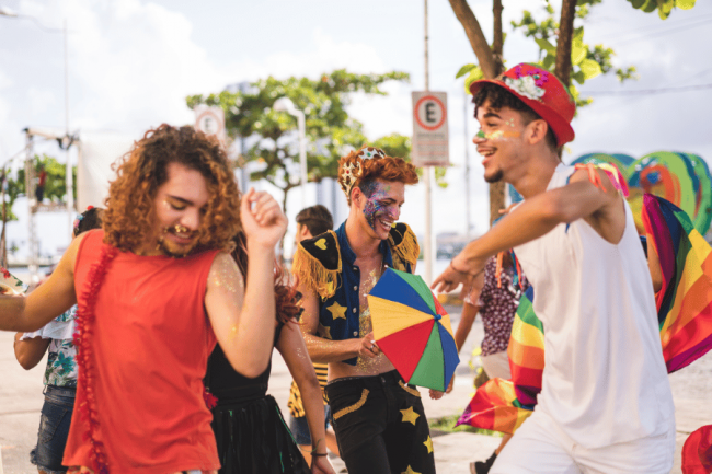 Grupo de personas disfrutando de los Carnavales de Tenerife con seguridad y alegría, evitando riesgos de lesiones gracias a medidas preventivas.